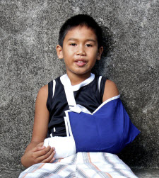 Young boy with left arm in blue sling